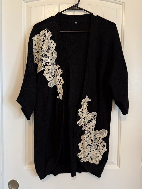 Sweaters - Chic black open-front cardigan with elegant white lace appliqué.